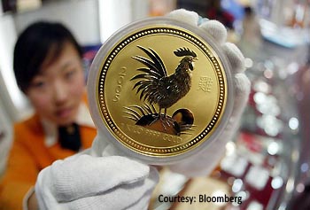 a-chinese-woman-displays-a-gold-coin-issued-by-the-australian-perth-mint-for-chinese-lunar-new-year-350